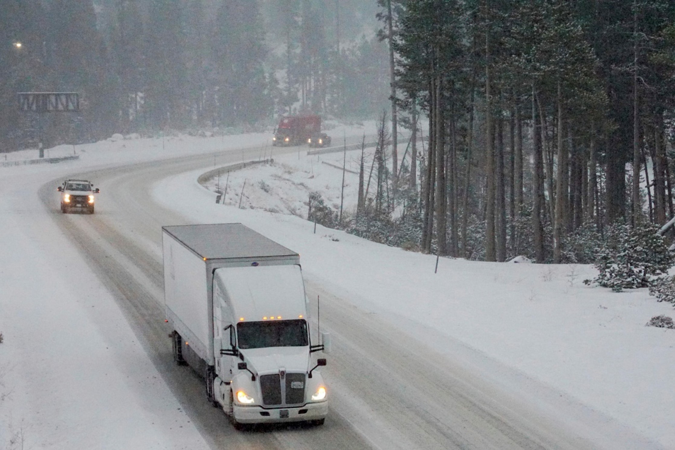 A truck navigates a snowy road, highlighting the extreme winter conditions amid discussions of global warming.
