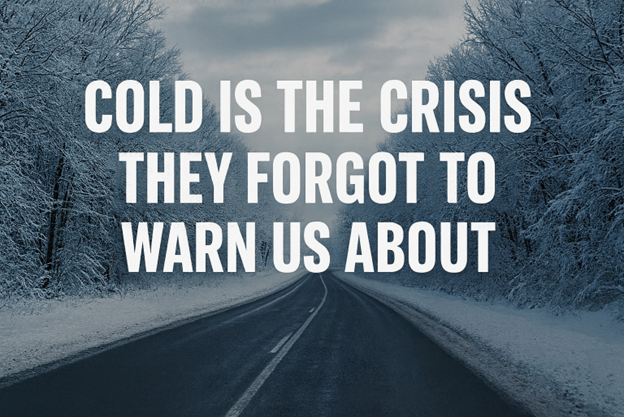 Snow-covered road surrounded by trees in winter with the text: “COLD IS THE CRISIS THEY FORGOT TO WARN US ABOUT.”