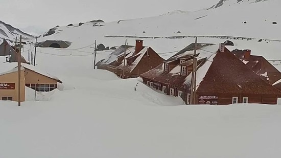 Buildings in Las Cuevas, Argentina, almost completely buried under deep snowfall following a powerful Andean winter storm.